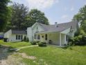 A quaint home with a well-maintained lawn and a detached garage, painted in a clean white at 7831 E 46Th St, Indianapolis, IN 46226