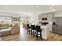 Open-concept kitchen with an island, seating, stainless steel appliances, and seamless flow to dining area at 843 Garrow Dr, Westfield, IN 46074