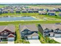 Expansive aerial view showcasing a neighborhood with a pond, green spaces, and neatly arranged homes at 9053 Fitzgerald Dr, Indianapolis, IN 46239