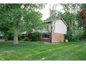 Rear exterior showcasing brick and siding details, a lush lawn, and mature trees for privacy at 919 Dreamy St, Greenwood, IN 46142