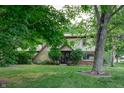Lovely front exterior showcasing a well-kept lawn, mature trees, and a welcoming entrance with chairs at 919 Dreamy St, Greenwood, IN 46142