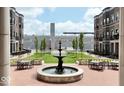 Charming courtyard showcasing lush green space, a decorative fountain, and inviting seating areas at 925 Veterans Way # 101, Carmel, IN 46032