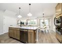 Open-concept kitchen with a large island, stainless steel appliances, and an adjacent dining area and living space at 9737 Oleander Dr, Fishers, IN 46250
