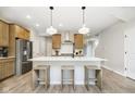 Bright kitchen features an island with seating, modern appliances, wood cabinetry, and stylish pendant lights at 9737 Oleander Dr, Fishers, IN 46250