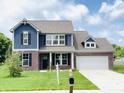 Charming two-story home featuring a brick and blue wood facade, with a well-manicured lawn at 980 S Raylee Garden Dr, New Palestine, IN 46163
