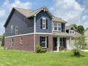 Charming two-story home featuring a brick and blue wood facade at 980 S Raylee Garden Dr, New Palestine, IN 46163