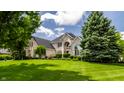 Expansive front lawn view of an elegant brick home showcasing lush landscaping and mature trees at 1037 Deer Lake Dr, Carmel, IN 46032