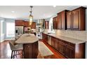 Spacious kitchen with dark wood cabinets, stainless steel appliances, and a large island with seating at 10587 Proposal Pointe Way, Fishers, IN 46040