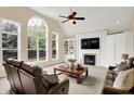 Bright living room with large windows, a fireplace, custom built-ins, and comfortable seating at 10587 Proposal Pointe Way, Fishers, IN 46040