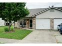 Charming brick home featuring a well-manicured lawn and attached two car garage at 1059 Wild Ivy Trl, Franklin, IN 46131