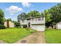 Well-maintained two-story home with a lush green lawn, small storage shed, and concrete driveway at 1103 Rosengarten Dr, Greenwood, IN 46142