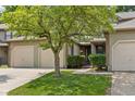 Lovely exterior of a multi-unit home featuring well-manicured lawns, mature shade tree, and attached garages at 11529 Sunset Cove Ln # 11529, Indianapolis, IN 46236