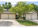 Lovely exterior of a multi-unit home featuring well-manicured lawns, mature shade tree, and attached garages at 11529 Sunset Cove Ln # 11529, Indianapolis, IN 46236