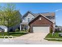Charming two-story home featuring a brick front, two-car garage, and well-manicured lawn at 12584 Cold Stream Rd, Noblesville, IN 46060