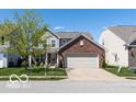 Charming two-story home featuring a brick front, two-car garage, and well-manicured lawn at 12584 Cold Stream Rd, Noblesville, IN 46060