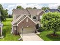 Aerial view showcasing a lovely two-story home, mature trees, and a basketball hoop in the driveway at 13700 Stanford Dr, Carmel, IN 46074
