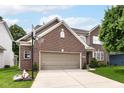 Charming brick front home featuring an attached two-car garage and a well-manicured lawn at 13700 Stanford Dr, Carmel, IN 46074