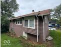 A side view of the home's exterior showing window placement and the basement at 1521 N Tacoma Ave, Indianapolis, IN 46201