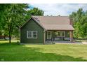 Charming home with a cozy covered porch, complemented by manicured lawn and mature trees at 155 Hoover Dr, , IN 46164