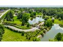 Aerial shot showcasing the lush landscape, winding road and beautiful pond at 18 Lost Run Ln, Zionsville, IN 46077