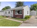 Well-kept single-story home with a manicured lawn, flower beds, and a detached garage offering a welcoming curb appeal at 206 Allen Ln, Greenfield, IN 46140