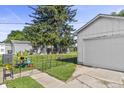Detached white garage with a well-maintained yard, featuring a fenced-in area and colorful plants adding charm at 206 Allen Ln, Greenfield, IN 46140
