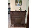 A brick fireplace with decorative artwork offers charm to the living area at 2830 Guilford Ave, Indianapolis, IN 46205