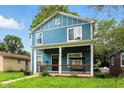 Charming two-story home with a welcoming front porch and swing, perfect for relaxing outdoors and a manicured front lawn at 3210 Hovey St, Indianapolis, IN 46218