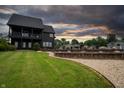 Landscaped backyard with decorative rocks, a retaining wall, lush lawn, and a partial view of the house at 3306 Mullinix Rd, Greenwood, IN 46143