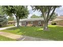 Charming brick ranch home featuring mature trees and a well-maintained lawn at 408 Ottawa Dr, Indianapolis, IN 46217