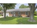 Charming brick ranch home with an attached garage and manicured front yard at 408 Ottawa Dr, Indianapolis, IN 46217