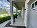 Inviting front porch with white brick accents, potted plants and an outdoor seating area at 4281 Viewforth Ln, Bargersville, IN 46106