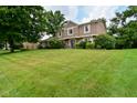 Traditional two-story house with a well-maintained green lawn, mature trees, and manicured landscaping at 4585 Abbey Dr, Carmel, IN 46033