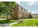Brick townhomes on well-maintained lawn with sidewalk and trees on the side at 49 Druid Hill Ct # 0, Carmel, IN 46032