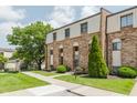 Brick townhome on well-maintained lawn with sidewalk and large tree on the side at 49 Druid Hill Ct # 0, Carmel, IN 46032