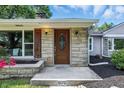 Close-up of front entrance featuring decorative door, stone veneer, shutters, and address numbers at 5170 Mt Pleasant N St, Greenwood, IN 46142