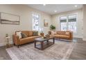 Bright living room with two leather sofas, neutral walls, and a modern coffee table on stylish carpet at 5511 E University Ave, Indianapolis, IN 46219