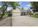 Spacious concrete driveway leading to a two car garage surrounded by mature trees and landscaping at 5591 Royal Troon Way, Avon, IN 46123