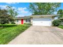 Attractive single-story home with a well-maintained lawn, a bright red front door, and a 2-car garage at 621 S Jefferson St, Brownsburg, IN 46112