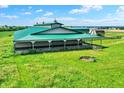 An aerial view showcasing a spacious barn with green roof, surrounded by lush green fields and mature trees at 7165 W State Road 252 W Rd, Edinburgh, IN 46124