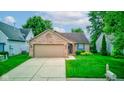 Charming single-story brick home with a two-car garage, manicured lawn, and a welcoming garden at 741 Chestnut Ln, Brownsburg, IN 46112
