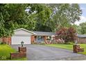 Charming single-story brick home featuring an attached garage and a well-maintained front yard and patriotic decor at 7651 Sherry Ln, Brownsburg, IN 46112