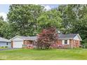 Charming single-story brick home featuring an attached garage and a well-maintained front yard and patriotic decor at 7651 Sherry Ln, Brownsburg, IN 46112