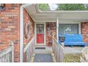Inviting brick front porch with decorative accents including a wooden railing, potted plants, and charming decor at 7651 Sherry Ln, Brownsburg, IN 46112