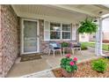 Cozy front porch with seating, potted flowers, and charming details, creating a welcoming entrance at 7911 Bentley Commons Dr, Indianapolis, IN 46259