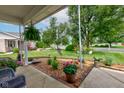 Inviting front porch view showcases manicured lawn, decorative plants, and a relaxing outdoor seating area at 7911 Bentley Commons Dr, Indianapolis, IN 46259