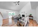 Bright living room featuring hardwood floors, a ceiling fan, a fireplace, and sliding glass doors to a patio at 8178 Foxchase Cir, Indianapolis, IN 46256