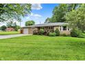 Beautiful one-story home with a lush green lawn, mature trees, and a welcoming front porch at 8760 Big Bend Rd, Martinsville, IN 46151