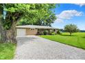 Inviting one-story home with a gravel driveway, green lawn, and mature trees creating a peaceful setting at 8760 Big Bend Rd, Martinsville, IN 46151