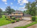 Beautiful tan home with a two-car garage and a well manicured front yard on a sunny day at 904 Dreamy St, Greenwood, IN 46142